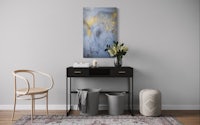 an abstract painting hangs on a wall in a living room