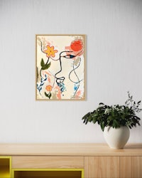 a framed painting of a woman's face with flowers