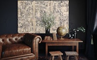 a black and white living room with a brown leather chair and a vase