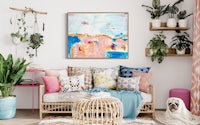 a living room with a colorful painting and a dog