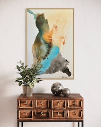 an abstract painting hangs above a dresser in a living room
